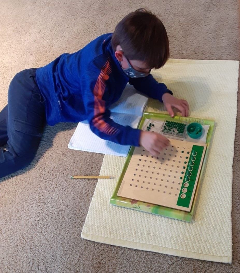 Paoli Campus: A child is very focused on working with the Division Bead Board. This activity helps the child in understanding the process of division.